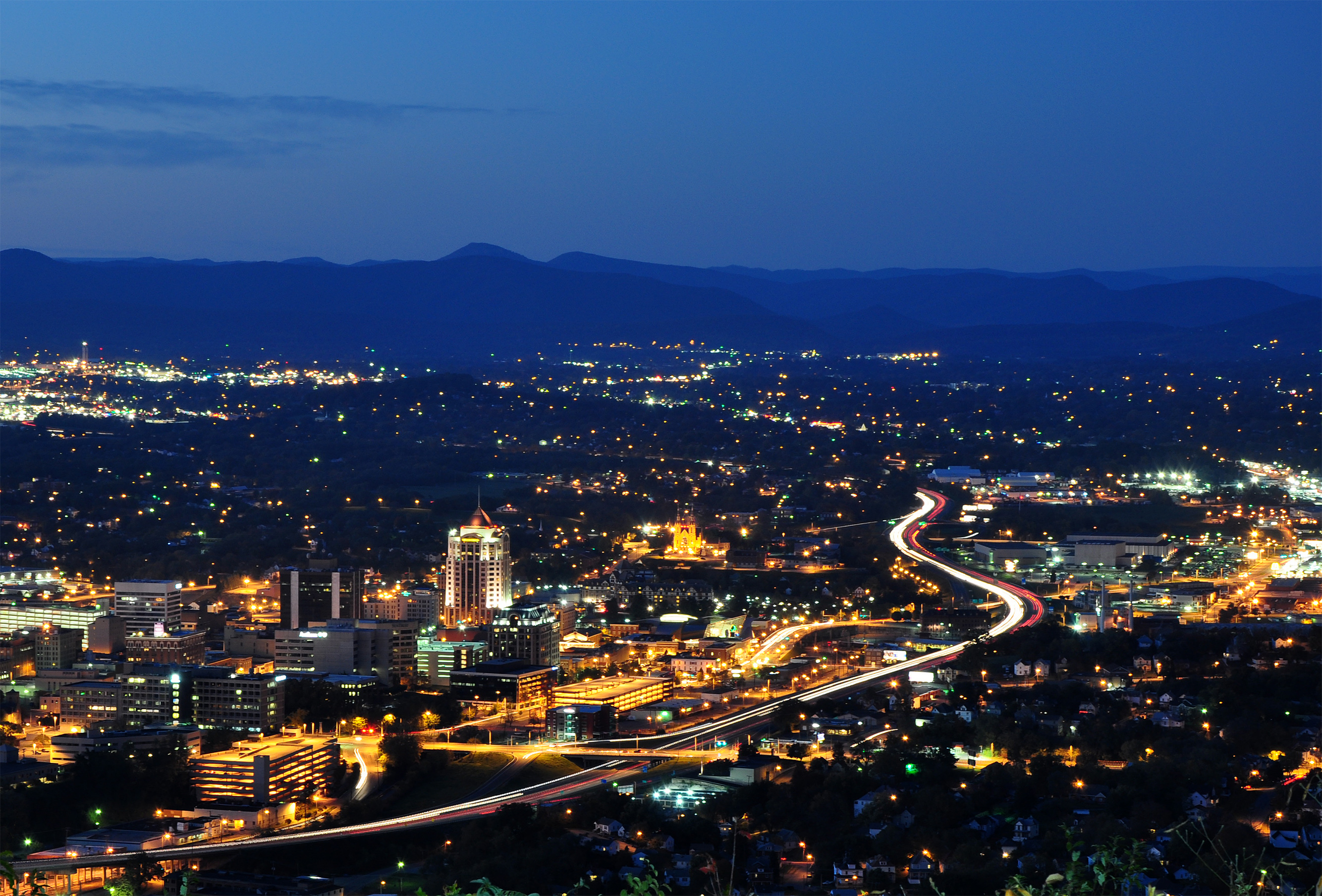 Roanoke ( ROH-ə-nohk) is an independent city in the U.S. state of Virginia. It is located in Southwest Virginia along the Roanoke River, in the Blue Ridge range of the greater Appalachian Mountains. Roanoke is approximately 50 miles (80 km) north of the Virginia–North Carolina border and 250 miles (400 km) southwest of Washington, D.C., along Interstate 81. At the 2020 census, Roanoke's population was 100,011, making it the largest city in Virginia west of the state capital Richmond. It is the primary population center of the Roanoke metropolitan area, which had a population of 315,251 in 2020.
The Roanoke Valley was originally home to members of the Siouan-speaking Tutelo tribe. However, in the 17th and early-to-mid 18th centuries, Scotch-Irish and later German American farmers gradually drove those Native Americans out of the area as the American frontier pressed westward. In 1882, the Norfolk and Western Railway (N&W) chose the small town of Big Lick as the site of its corporate headquarters and railroad shops. Within two years, the town had become the City of Roanoke. With a 2,300% population growth rate in the decade from 1880 to 1890, the young city experienced the advantages and disadvantages of its boomtown status. During the 20th century, Roanoke's boundaries expanded through multiple annexations from the surrounding Roanoke County, and it became Southwest Virginia's economic and cultural hub. The 1982 decision by N&W to relocate their headquarters out of the city, combined with other manufacturing closures, led Roanoke to pivot to a primarily service economy. In the 21st century, a robust healthcare industry and the development and increased marketing of its outdoor amenities have helped reverse prior declining population trends.
Roanoke is known for the Roanoke Star, an 88.5-foot-tall (27.0 m) illuminated star that sits atop a mountain within the city's limits and is the origin of its nickname, "The Star City of the South". Other points of interest include the Hotel Roanoke, a 330-room Tudor Revival structure built by N&W in 1882, the Taubman Museum of Art, designed by architect Randall Stout, and the city's farmer's market, the oldest continuously operating open-air market in the state. The Roanoke Valley features 26 miles of greenways with bicycle and pedestrian trails, and the city's location in the Blue Ridge Mountains provides access to numerous outdoor recreation opportunities.